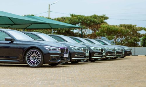 Row of luxury cars parked at an outdoor dealership, showcasing elegance.