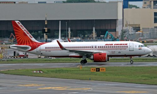 Air India Airbus A320 parked on runway at an airport, ready for departure.